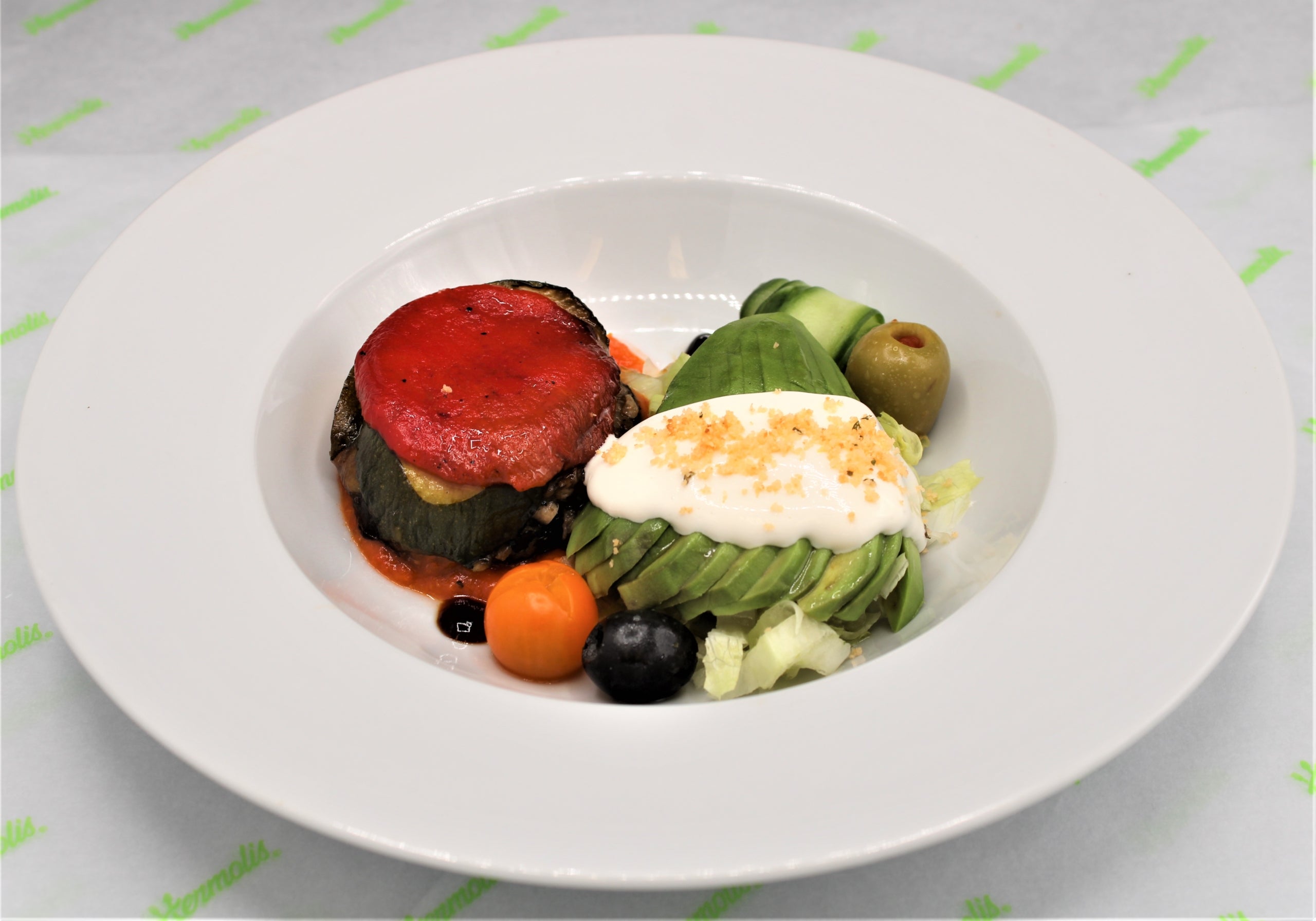 Tower of Grilled Mediterranean Vegetables On a Bed of Red Pepper Coulis with Fanned Avocado served with a Mixed Leaf & Sun Blushed Tomato Salad with Balsamic Vinegar and Herb Mayonnaise