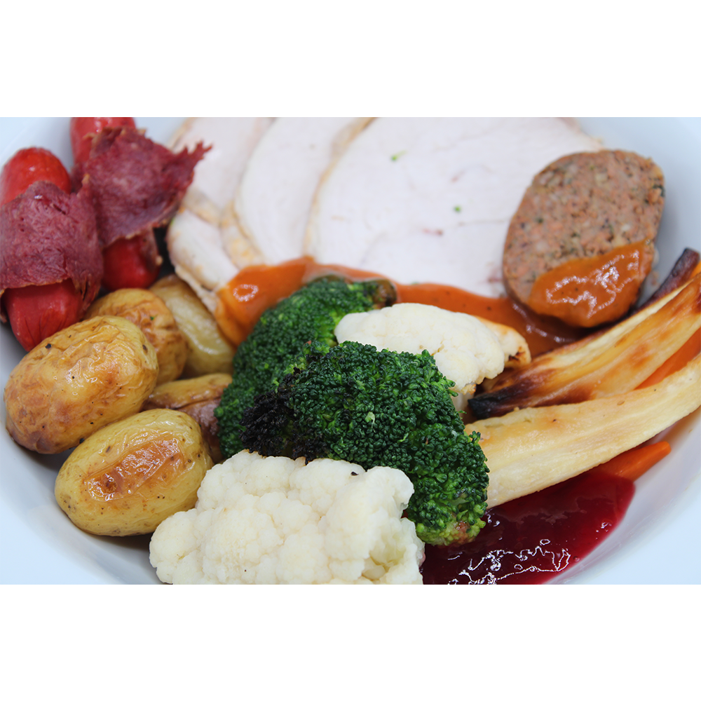Roast Turkey with Stuffing and Cranberry Sauce served with Chipolatas wrapped in Salt Beef, Broccoli, Cauliflower, Carrots, Roasted Parsnips and Roasted New Potatoes